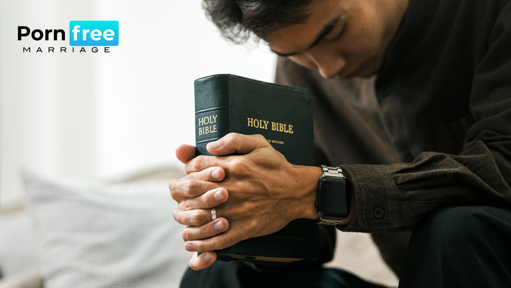 Christian man holding a Holy Bible with head hung down