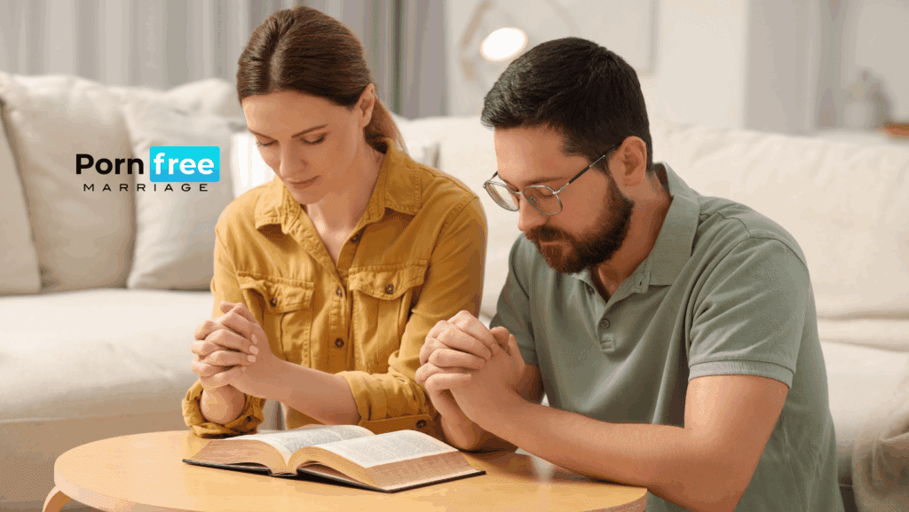 Married Christian couple holding hands in prayer over an open Bible, symbolizing faith and unity in overcoming pornography struggles in marriage.